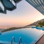 Infinity pool with breathtaking mountain and city views, perfect for a luxury tropical getaway.